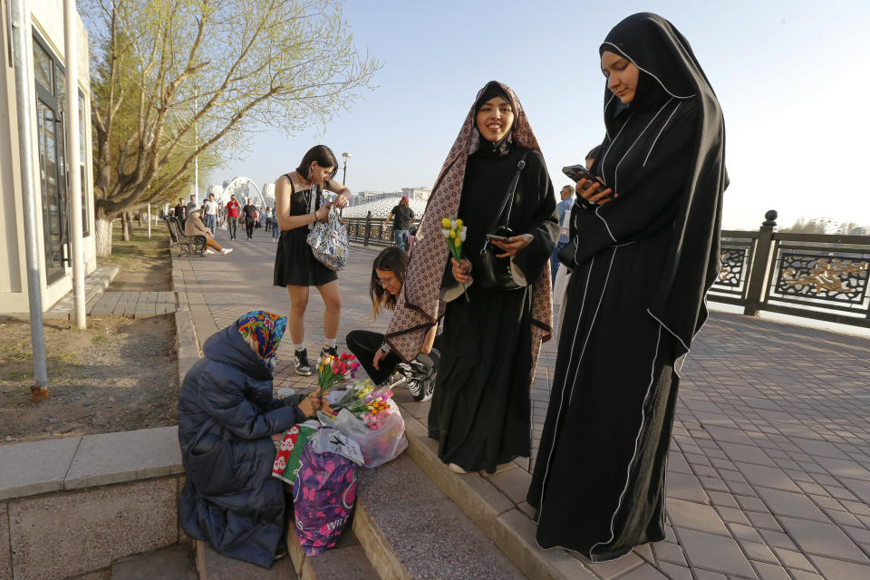 Two women buy flowers in Astana, Kazakhstan, on Sunday, April 21, 2024. A high-profile trial involving the killing of Saltanat Nukenova has raised awareness of spousal abuse in the Central Asian country. Businessman and former Economics Minister Kuandyk Bishimbayev is on trial for the killing of Nukenova. Tens of thousands of people have signed petitions calling for harsher penalties for domestic violence. On April 11, senators approved a bill toughening punishment for spousal abuse, and President Kassym-Jomart Tokayev signed it into law four days later. (AP Photo/Stanislav Filippov)