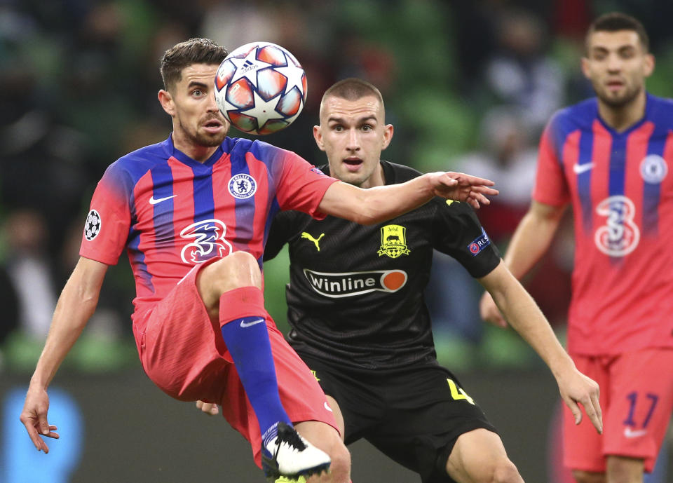 Jorginho (izquierda), del Chelsea, disputa un balón con Daniil Utkin, del Krasnodar, disputan un balón en un encuentro de la Liga de Campeones, el miércoles 28 de octubre de 2020 (AP Foto)