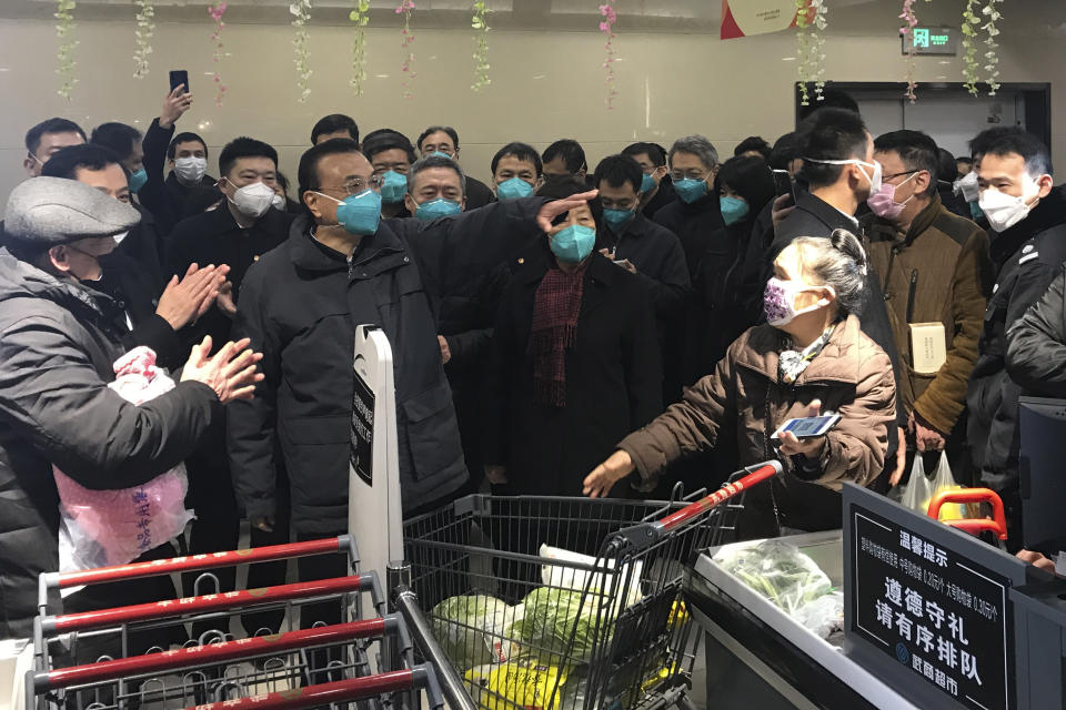Chinese Premier Li Keqiang, center left talks to shoppers at a supermarket in Wuhan in central China's Hubei province Monday, Jan. 27, 2020. On Monday, China's No. 2 leader, Premier Li Keqiang, visited Wuhan to "guide epidemic prevention work," the Cabinet website said. (Chinatopix Via AP)