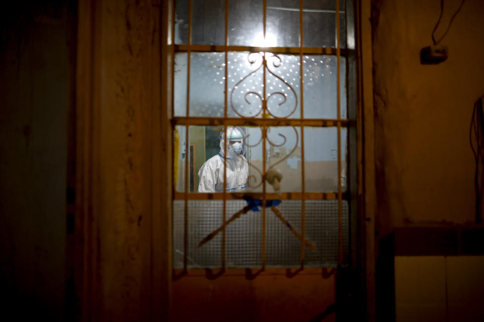 Ambulance Doctor Vladimir Canal enters a home to attend a COVID-19 patient with oxygen problems after an emergency call to the residence during his night shift in Lomas de Zamora, Argentina, late Thursday, June 10, 2021. (AP Photo/Natacha Pisarenko)