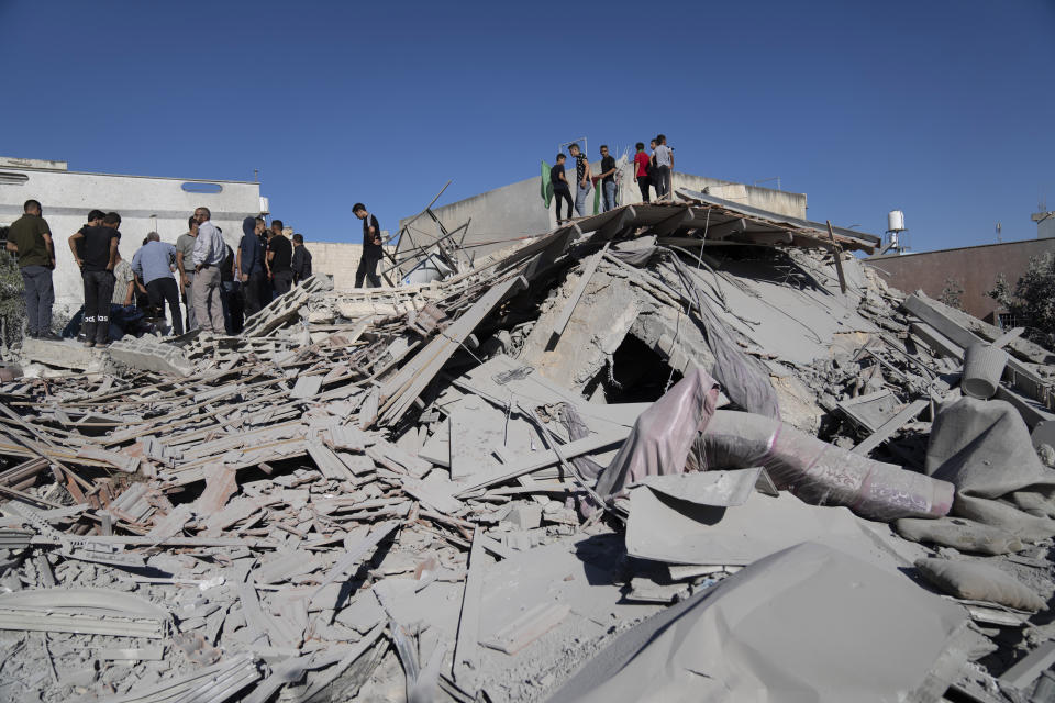 Palestinians gather on top of the rubble of the family house of Yahia Merai, that was demolished by Israeli army forces, in the West Bank town of Qarawat Bani Hassan, Salfit, Tuesday, July 26, 2022. Israeli soldiers demolished the residences of Palestinian attackers Yahia Merai and Youssef Assi who committed the deadly attack in the Israeli settlement of Ariel in April 2022, the Israeli army said. (AP Photo/Nasser Nasser)