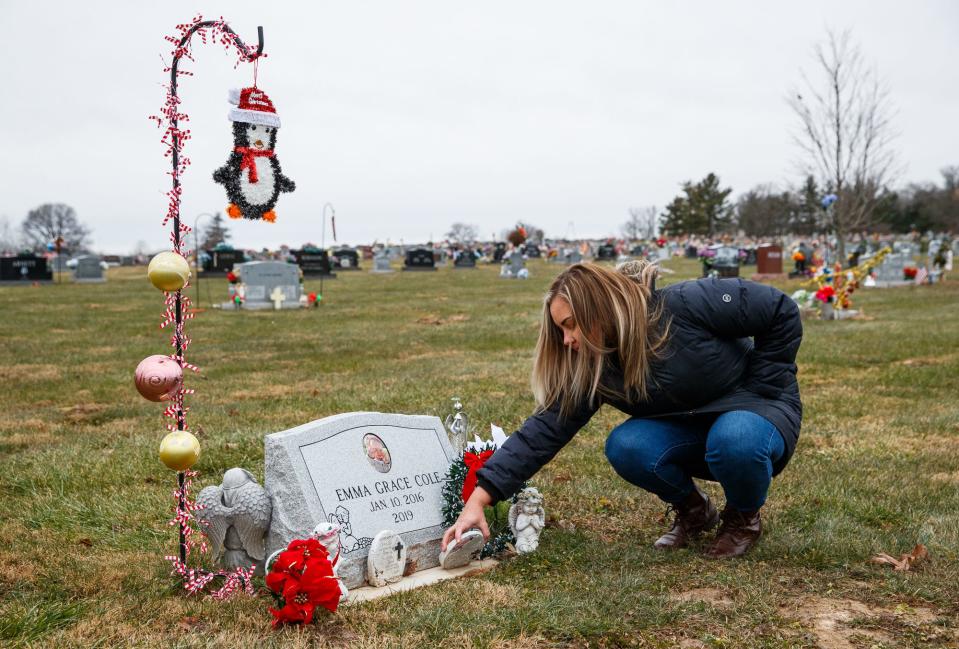 Kelsey Cole Navarro, sister of Kristie Cole Haas, stands at the gravesite of her niece, Emma Grace Cole, on Tuesday, Dec. 7, 2021, at Clear Creek Cemetery in Bloomington, Ind. "You choke up and you can't really breathe and think about a whole lot else except that a baby is in there and shouldn't be in there," Kelsey said.