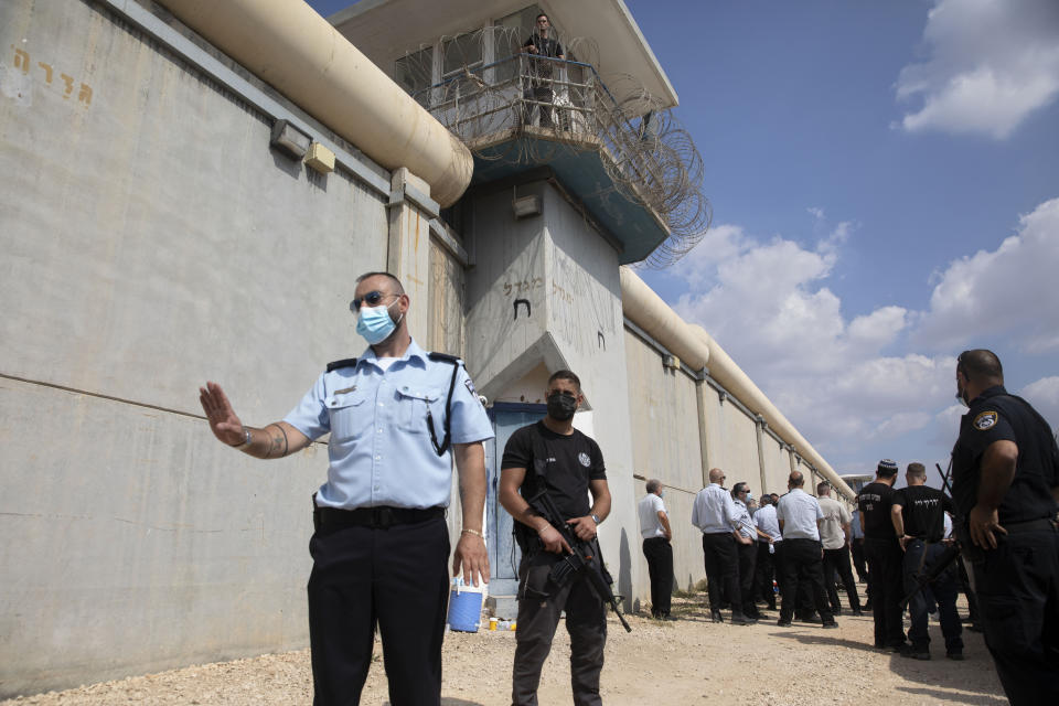 Police officers and prison guards inspect the scene of a prison escape outside the Gilboa prison in northern Israel, Monday, Sept. 6, 2021. Israeli forces on Monday launched a massive manhunt in northern Israel and the occupied West Bank after several Palestinian prisoners escaped overnight from the high-security facility in an extremely rare breakout. (AP Photo/Sebastian Scheiner)