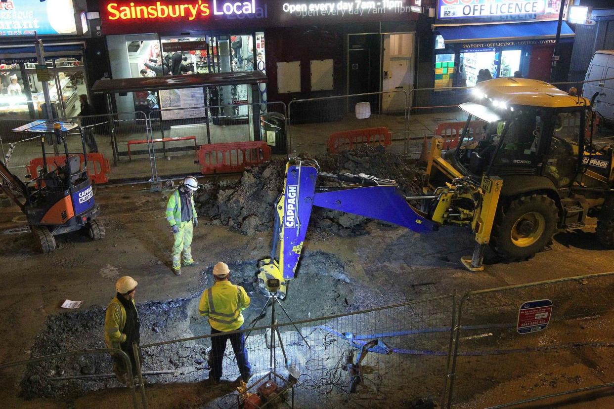 Engineers from Thames Water inspect and repair a burst water main: NIGEL HOWARD