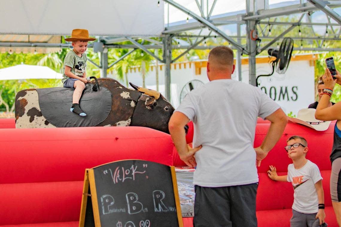 A customer rides the mechanic bull while his family watches at Royd’s.