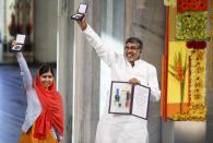 Nobel Peace Prize laureates Malala Yousafzai and Kailash Satyarthi (R) pose with their medals during the Nobel Peace Prize awards ceremony at the City Hall in Oslo December 10, 2014. Pakistani teenager Malala Yousafzai, shot by the Taliban for refusing to quit school, and Indian activist Kailash Satyarthi received their Nobel Peace Prizes on Wednesday after two days of celebration honouring their work for children's rights. REUTERS/Cornelius Poppe/NTB Scanpix/Pool (NORWAY - Tags: SOCIETY CIVIL UNREST TPX IMAGES OF THE DAY) NORWAY OUT. NO COMMERCIAL OR EDITORIAL SALES IN NORWAY.
