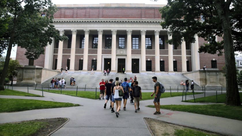 FILE - In this Aug. 13, 2019 file photo, students walk near the Widener Library in Harvard Yard at Harvard University in Cambridge, Mass. The Ivy League school announced Monday, July 6, 2020, that as the coronavirus pandemic continues its freshman class will be invited to live on campus this fall, while most other undergraduates will be required learn remotely from home. (AP Photo/Charles Krupa, File)