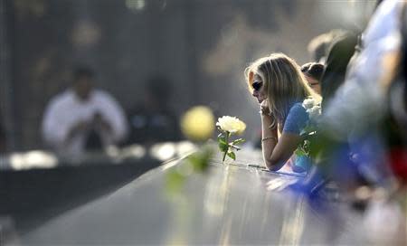 A woman pauses along the edge of the North Pool of the 9/11 Memorial during a ceremony marking the 12th anniversary of the 9/11 attacks on the World Trade Center in New York, September 11, 2013. REUTERS/Justin Lane/Pool