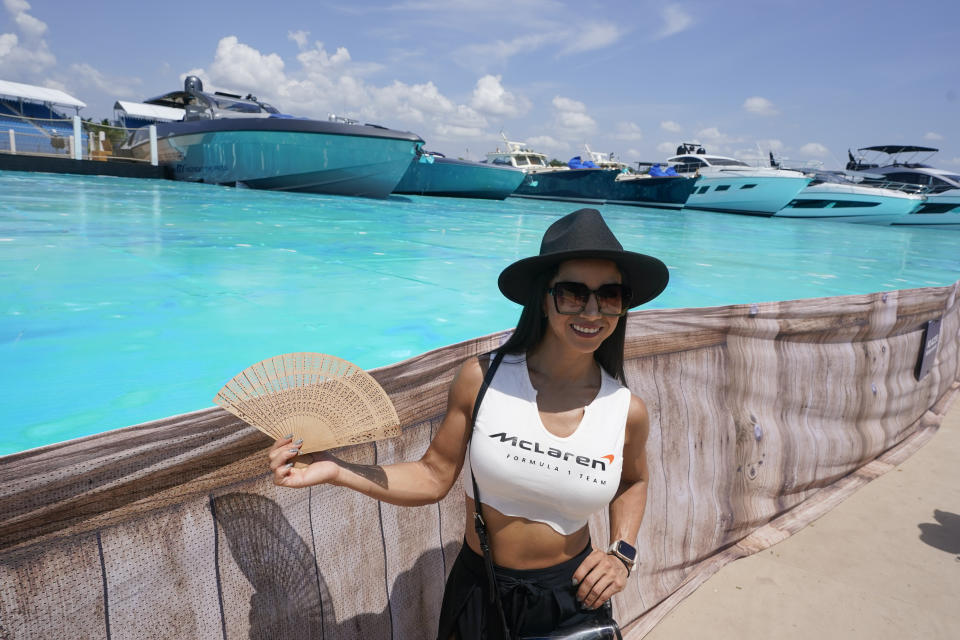 Luisa Velasquez poses in the man-made marina and beach club during the Formula One Miami Grand Prix auto race at Miami International Autodrome, Friday, May 6, 2022, in Miami Gardens, Fla. (AP Photo/Darron Cummings)