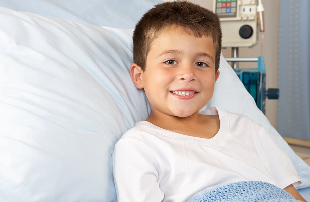 smiling boy in hospital bed