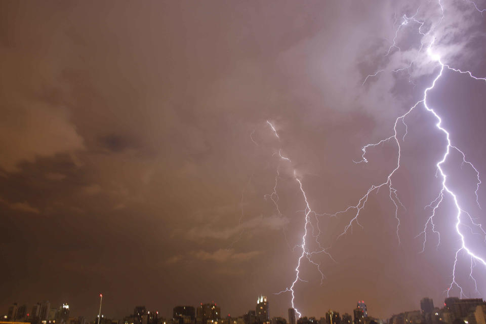 In this Jan. 1, 2014 photo, lightning strikes during a thunderstorm in Buenos Aires, Argentina. Argentines have suffered through a tough summer, with tropical rain that provided no relief from the heat and humidity, people having to throw out rotten food because of rolling power blackouts and soaring oil and gas prices, all amid rising inflation that is making it ever harder to reach the end of the month. The strain is evident on the faces of subway riders and others making their way home in Buenos Aires, where signs of poverty and decay are ubiquitous just beyond the glamorous streets where tourists go. (AP Photo/Rodrigo Abd)