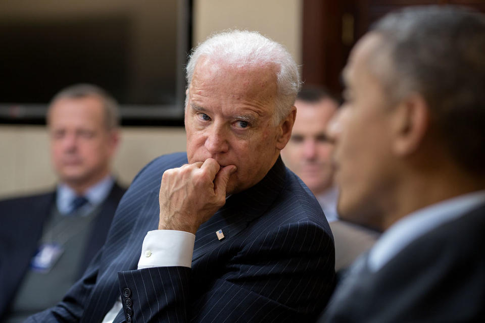 Former Vice President Joe Biden listening to former President Barack Obama speaking in a meeting.