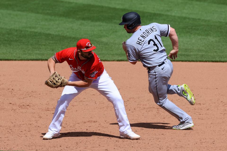 Reds third baseman Mike Moustakas fields the ball as Liam Hendriks of the White Sox tries to avoid him in the 10th inning of Cincinnati's 1-0 win.