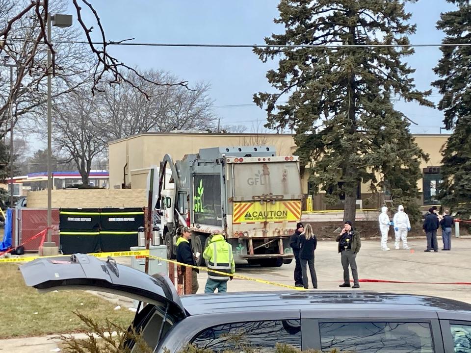 Workers in white full-body protective suits were spotted behind large crime scene barricades erected around the dumpsters at the South Milwaukee Pizza Hut.
