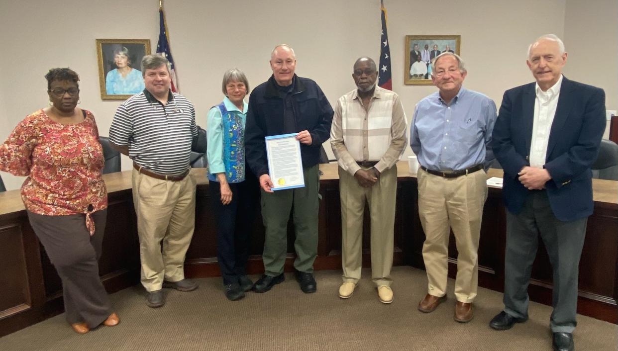 Louisville Police Chief Jimmy Miller accepts a proclamation recognizing his years of service to the city and community from the Louisville City Council.