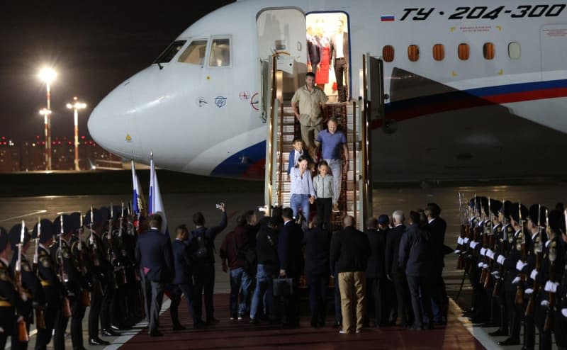 Russian President Vladimir Putin (C) welcomes prisoners released following the swap deal at Vnukovo International Airport in Moscow. -/KREMLIN/dpa