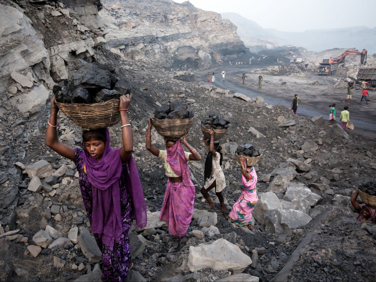 Girls collect coal from a mine in Dhanbad, India, in 2019 (Getty Images)