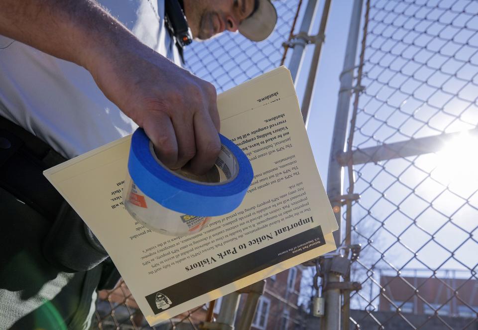 <p>A National Park Service ranger holds signs to tape on closed buildings at the Martin Luther King Jr. Historic Site after the federal government shutdown in Atlanta, Ga., Jan. 20, 2018. (Photo: Erik S. Lesser/EPA-EFE/REX/Shutterstock) </p>