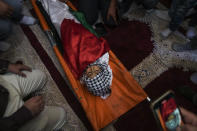 Mourners gather around the body of 7-year-old Palestinian boy Rayan Suleiman, during his funeral in the West Bank village of Tequa near Bethlehem Friday, Sept. 30, 2022. The U.S. State Department has called on Israel to open a "thorough" investigation into the mysterious death of the boy, who collapsed and died shortly after Israeli soldiers came to his home in the occupied West Bank. Relatives said he had no previous health problems and accused the army of scaring the child to death. The army called the death a tragedy and said its soldiers were not to blame. (AP Photo/Mahmoud Illean)