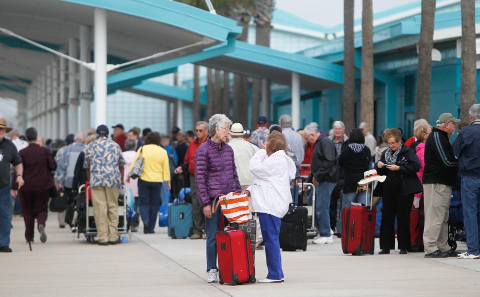 Passengers wait for their mode of transportation after getting off the Caribbean Princess cruise ship, Friday, Jan. 31, 2014, in La Porte, Texas. The ship returned to port early on Friday due to a dense fog advisory and not because people were vomiting and had diarrhea, a Princess Cruises spokeswoman said Friday. But passengers said the crew announced on the second day of the cruise that people were sick, apparently with highly contagious norovirus, and that extra precautions were being taken to ensure it didn’t spread. (AP Photo/Houston Chronicle, Cody Duty)