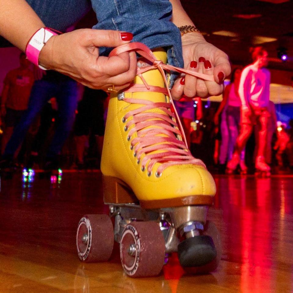 A roller-skater tightens her skates next to the rink during a skating party to mark the official closing of Super Wheels in Miami, Florida, on Saturday, November 25, 2023.