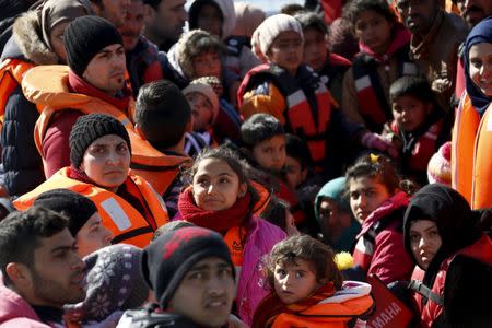 Refugees and migrants are seen on a dinghy as they approach the Ayios Efstratios Coast Guard vessel, during a rescue operation in the open sea between the Turkish coast and the Greek island of Lesbos, February 8, 2016. REUTERS/Giorgos Moutafis