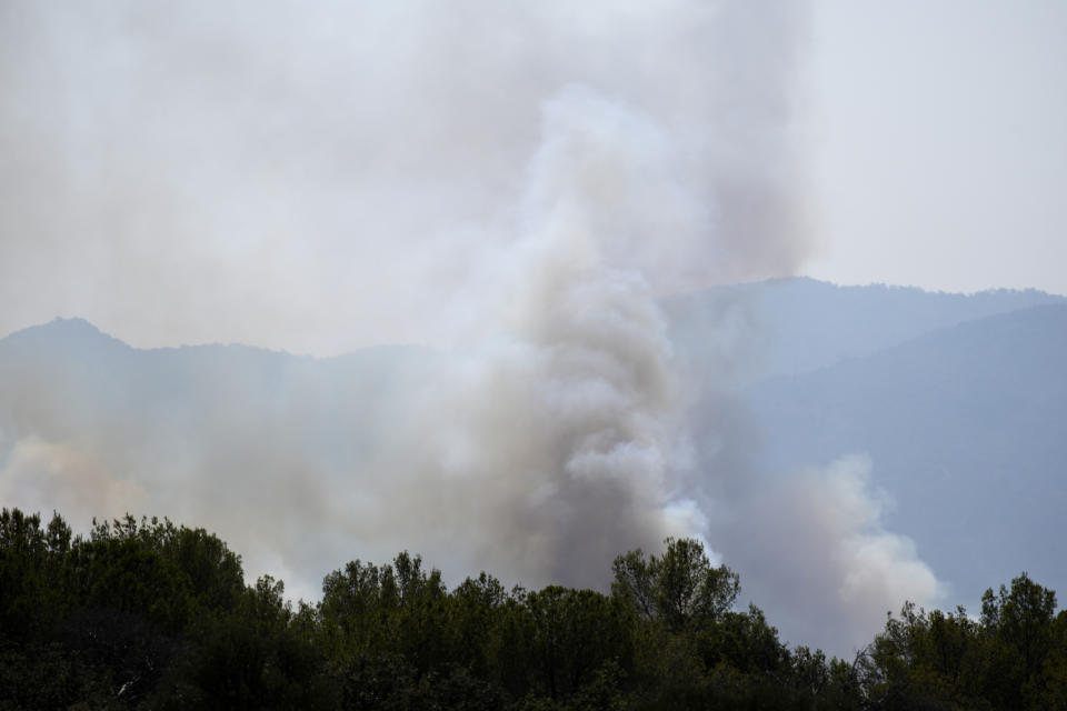 Smoke billows from the forest near La Garde-Freinet, southern France, Tuesday, Aug. 17, 2021. Hundreds of firefighters on Tuesday battled a fire racing through forests near the French Riviera that forced the evacuation of thousands of people from homes and vacation spots. (AP Photo/Daniel Cole)