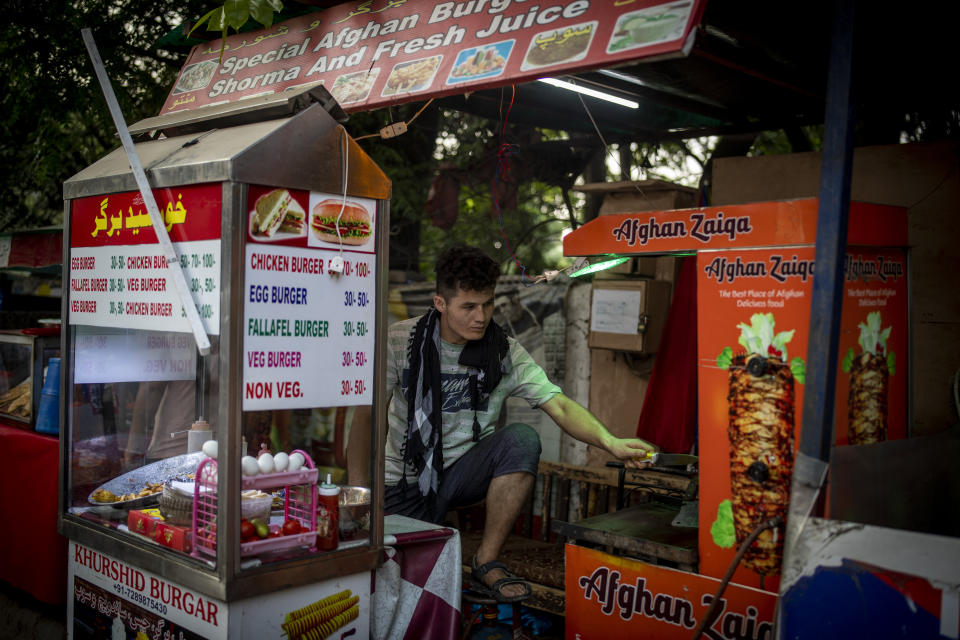 An Afghan refugee works at a fast food stall in New Delhi, India on Aug. 17, 2021. For thousands of Afghan refugees living in India, their plans to someday return home were dashed by the Taliban's shockingly swift takeover of the country. Some refugees struggle to put food on the table. Others are trapped in a complex bureaucratic process to register as refugees. What many thought would be a short, temporary escape has turned into a never-ending exile. (AP Photo/Altaf Qadri)