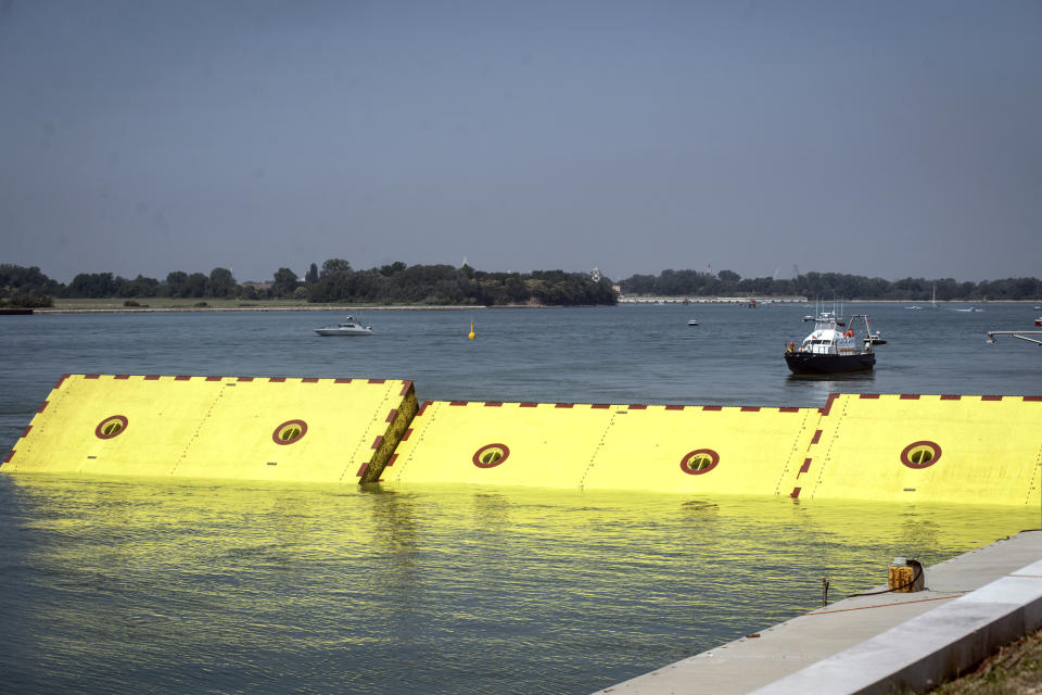 Moveable flood gates rise from the sea in the Venice lagoon, Italy, Friday, July 10, 2020. Venice has conducted a trial run an ambitious anti-flood system of 78 inflatable barriers in the hopes of protecting the lagoon city from devastating high tides. Premier Giuseppe Conte on Friday at a ceremony in Venice pressed a button that activated compressors to pump air into the bright yellow barriers, which then started rising from the sea to act a kind of a dike-on-demand. (Claudio Furlan/LaPresse via AP)