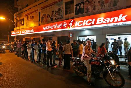 People wait to deposit and withdraw their money outside an ICICI Bank ATM in Rajkot, India, November 8, 2016. REUTERS/Amit Dave