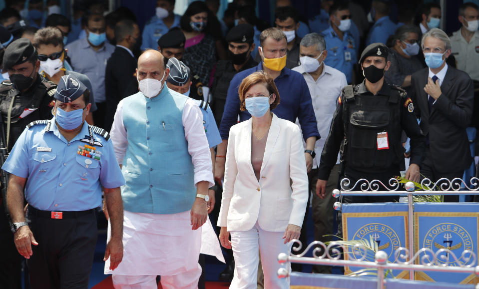 Indian Defense Minister Rajnath Singh, second left and French Defense Minister Florence Parly, right, walk during an induction ceremony of French-made Rafale fighter jets at Air Force Station Ambala, India, Thursday, Sept.10, 2020. The first batch of five planes, part of a $8.78 billion deal signed between the two countries in 2016 had arrived here in July. (AP Photo/Manish Swarup)