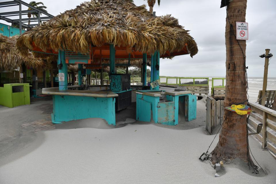 Sand, either blown by the wind, or carried by water, or both, covers the floor of the outdoor seating area at Sharky's on the Pier in Venice, Florida on Thursday, Sept. 29, 2022, following Hurricane Ian.