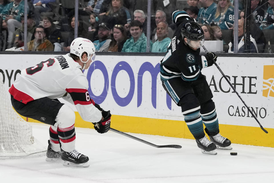 San Jose Sharks center Luke Kunin (11) skates toward the puck against Ottawa Senators defenseman Jakob Chychrun (6) during the first period of an NHL hockey game in San Jose, Calif., Saturday, March 9, 2024. (AP Photo/Jeff Chiu)