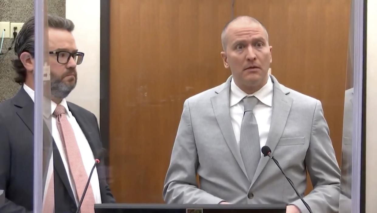 Former Minneapolis police Officer Derek Chauvin, right, accompanied by defense attorney Eric Nelson, addresses the court at his sentencing, hearing June 25.