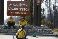 <p>Firefighters JJ Hawkinson, left, Brandon Bishop Parise, and Vanessa Aldrich, out of Ely, Nevada, take a lunch break while working on the Berry Fire in Grand Teton National Park, Wyo., Aug 25, 2016. Thursday, Aug 25, 2016 marks the 100th anniversary of the US National Park Service. (AP Photo/Brennan Linsley) </p>