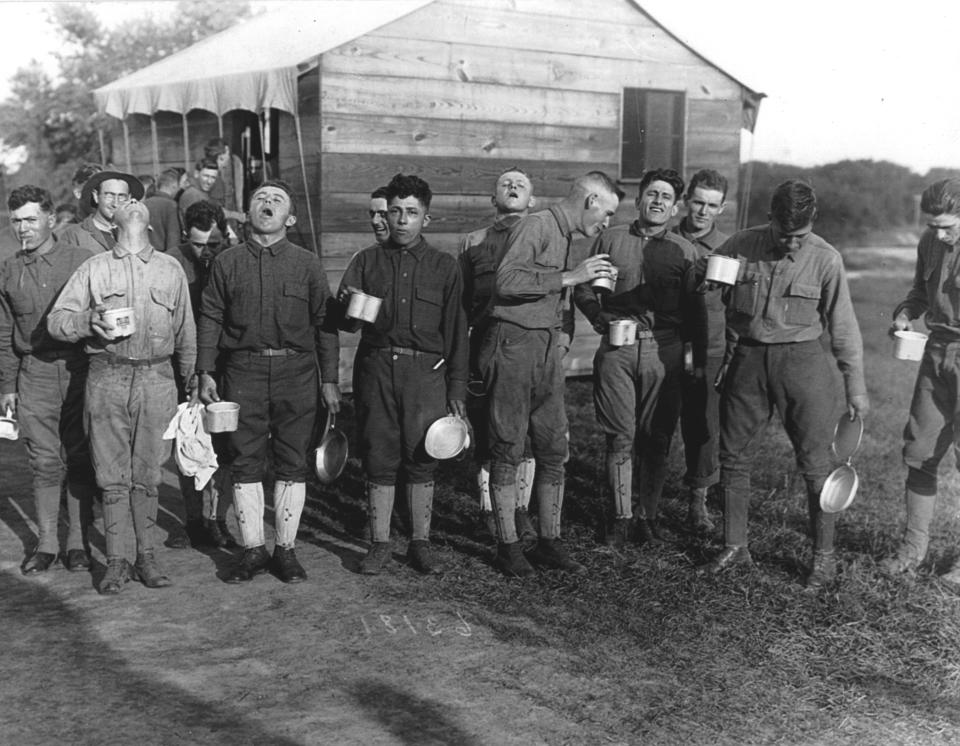 As protection against the influenza virus, men are seen gargling with salt and water after a day spent working in the War Garden at Camp Dix, New Jersey, September 1918. This was a preventative measure against the influenza epidemic that had spread to army camps. (Photo by PhotoQuest/Getty Images)