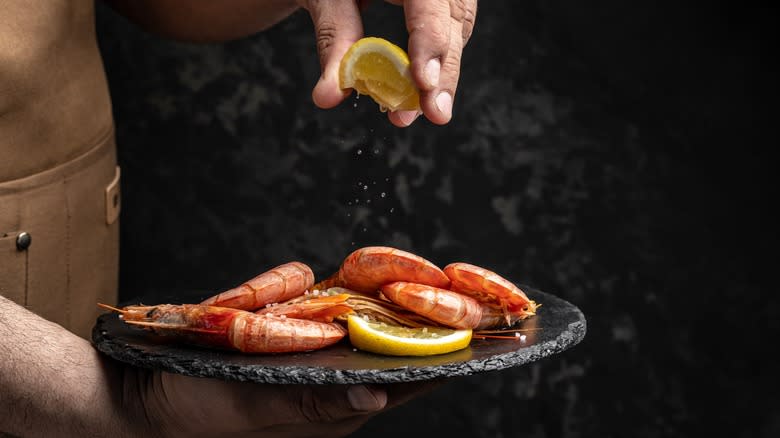 chef squeezing a little lemon over shrimp