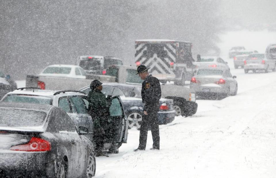 A Highway Patrol officer checks on the well being of a stranded motorist Wednesday, February 11, 2014 on Hammond Road in Raleigh, N.C. as snow pounds the Triangle. TRAVIS LONG/tlong@newsobserver.com