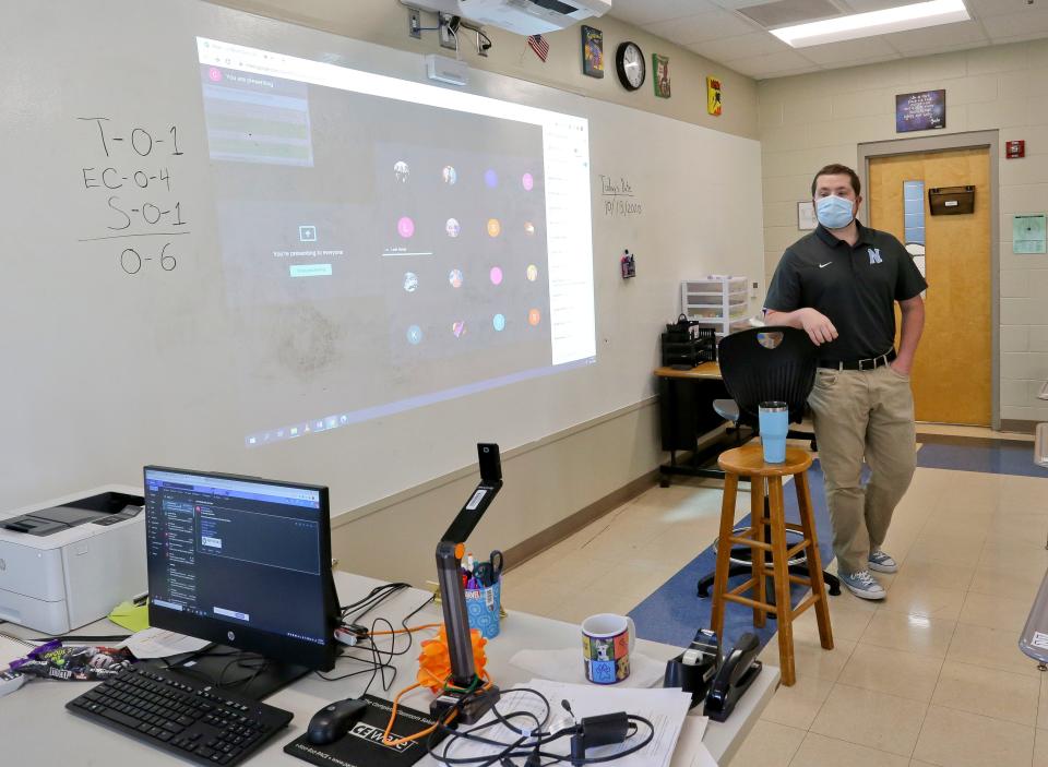 Clancy Bryant, an English teacher in Tuscaloosa, Alabama, teaches both in-person students and remote students who see him through the camera.