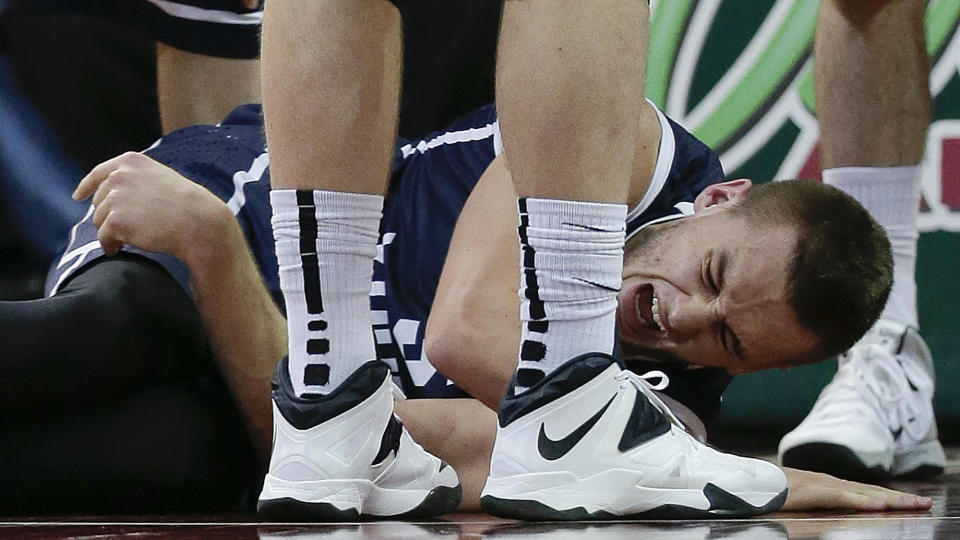 BYU's Kyle Collinsworth cringes in pain after an injury during the second half against Gonzaga in an NCAA college basketball game for the West Coast Conference men's tournament title, Tuesday, March 11, 2014, in Las Vegas. Collinsworth left the game and did not return. Gonzaga won 75-64. (AP Photo/Julie Jacobson)