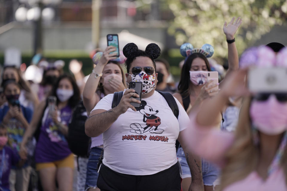 Guests walk down Main Street USA at Disneyland in Anaheim, Calif., Friday, April 30, 2021. The iconic theme park in Southern California that was closed under the state's strict virus rules swung open its gates Friday and some visitors came in cheering and screaming with happiness.(AP Photo/Jae Hong)