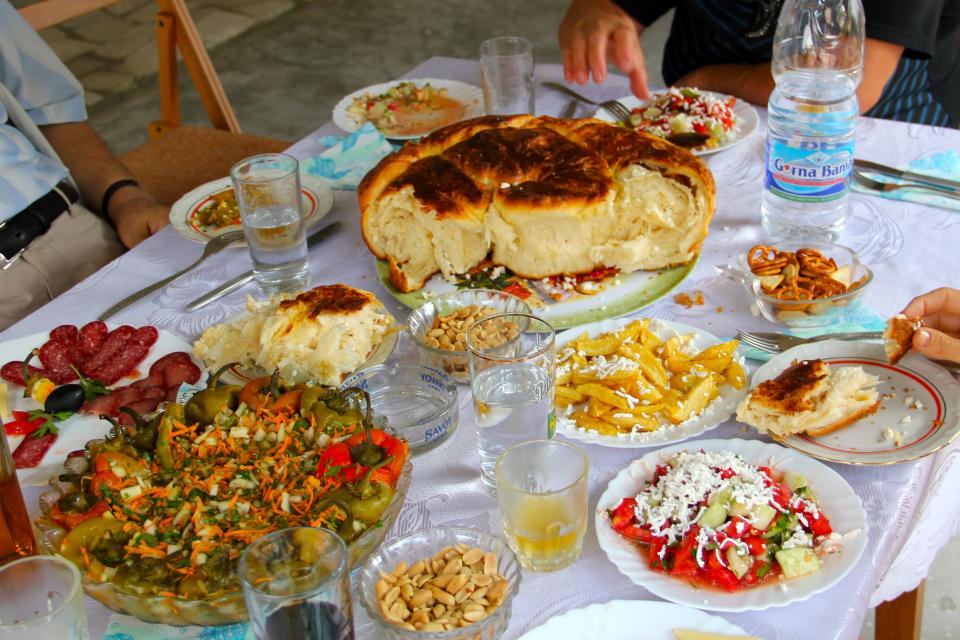 This Aug. 17, 2012 photo released by Mikhail Iliev shows a traditional Bulgarian feast, including shopska salad, lower right, a salad of peppers, lower left, and a bread with feta cheese called pogatcha in Bulgaria. (AP Photo/Mikhail Iliev)