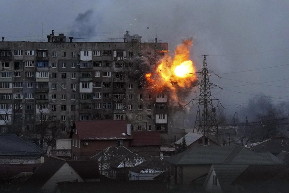 FILE - An explosion is seen in an apartment building after Russian's army tank fires in Mariupol, Ukraine, March 11, 2022. Six months ago, Russian President Vladimir Putin sent troops into Ukraine in an unprovoked act of aggression, starting the largest military conflict in Europe since World War II. Putin expected a quick victory but it has turned into a grinding war of attrition. Russian offensive are largely stuck as Ukrainian forces increasingly target key facilities far behind the front lines. (AP Photo/Evgeniy Maloletka, File)