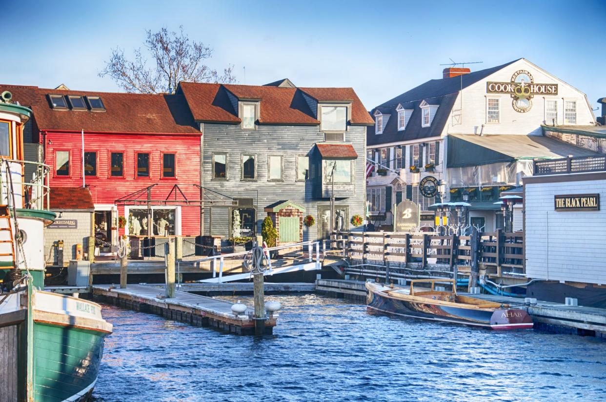 Boats and various shops located at the harbor in Newport Rhode Island in the setting sun.