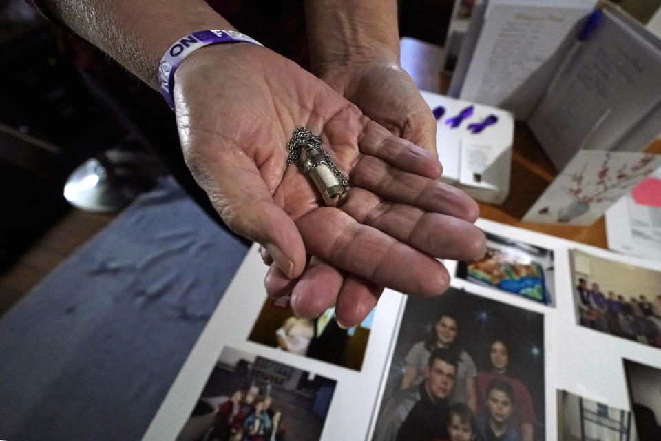 Trina Cotter holds a pendant containing some of the ashes of her son, Zach Robinson, during an interview at their family home, Thursday, Nov. 30, 2023, in Dover, N.H. Robinson spent decades trying to fight off nightmares about being raped as a child at New Hampshire’s youth detention center. He died last in November, still waiting for accountability for his alleged abusers. (AP Photo/Charles Krupa)