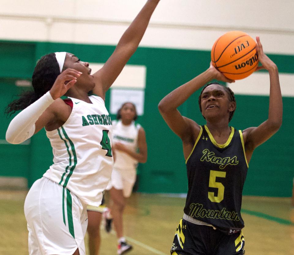 Kings Mountain's Myracle Davis lifts a 3-pointer over the outstretched arm of Ashbrook's Kennette Bess during Friday's Big South 3A matchup in Gastonia.