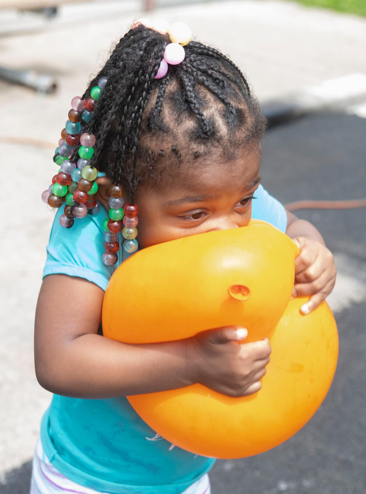 Two-year-old Daiyana Davis plays with a balloon Saturday at the back-to-school event Saturday at King Kennedy Community Center in Ravenna.