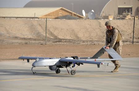 A U.S. Marine with Marine Unmanned Aerial Vehicle Squadron 1 pushes an RQ-7B Shadow UAV following its landing at Camp Leatherneck, Afghanistan in this November 10, 2011 USMC handout photo obtained by Reuters February 6, 2013. To match Exclusive AFGHANISTAN-DRONES/ U.S. Marine Corps/Sgt. Eric D. Warren/Handout via Reuters/File Photo ATTENTION EDITORS - THIS IMAGE HAS BEEN SUPPLIED BY A THIRD PARTY. FOR EDITORIAL USE ONLY.