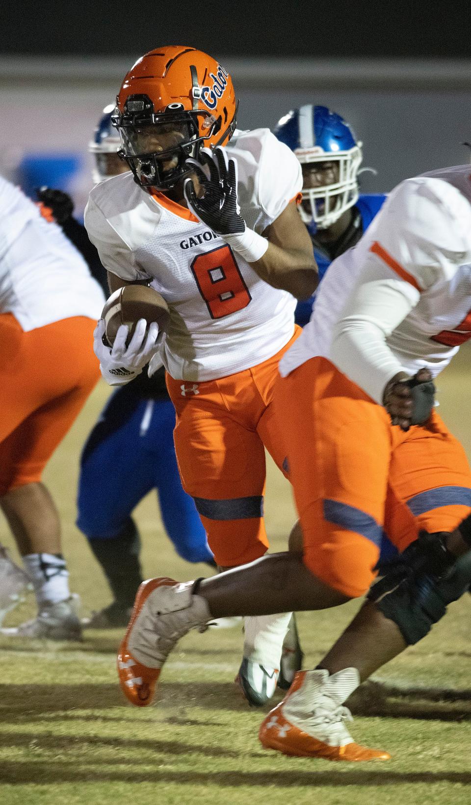 Escambia's Tyqan Stabler (No. 8) zig-zags his way through the line of scrimmage during the Friday Night district game against Washington. 