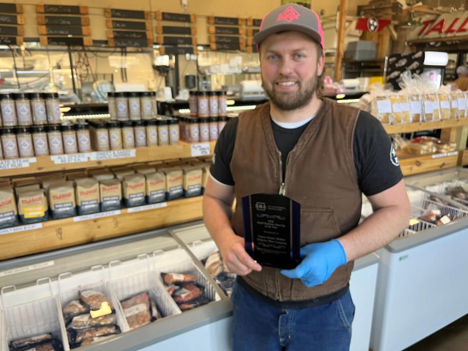 Casey Weber, owner of Tallgrass Meat Co., holds his award for Small Business Start-up of the Year for 2020 at the store on Jan. 20, 2023.